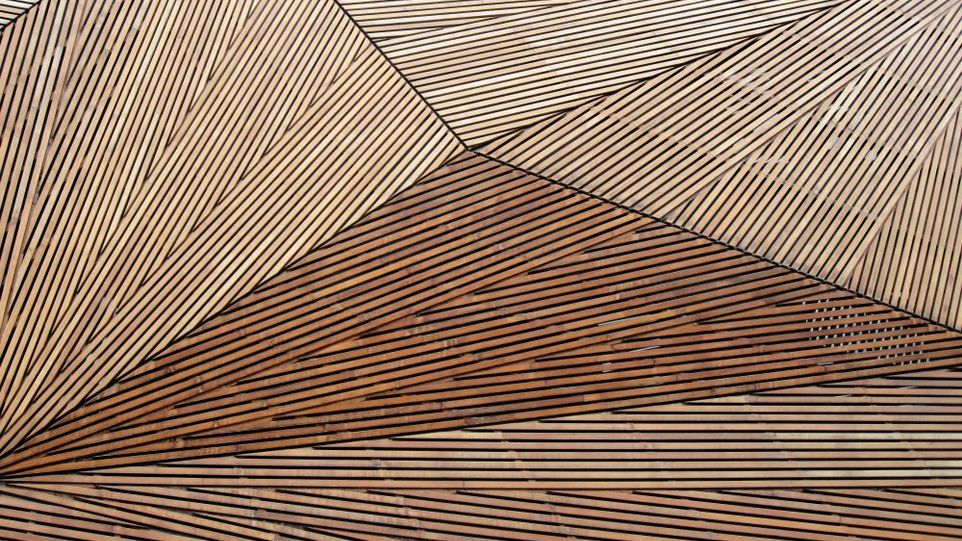 Wohnen in Städten aus Holz könnte Emissionen vermeiden – ohne Ackerland für die Holzproduktion zu nutzen Geometrisches Muster aus Holzplanken