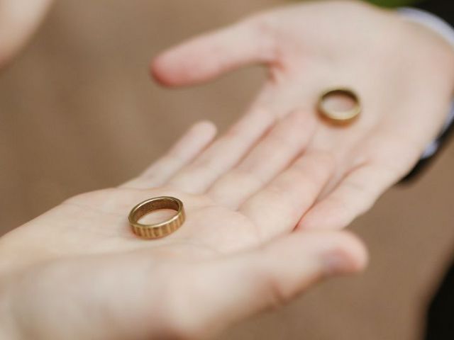 Ringe auf den ausgestreckten Handflächen der Eheleute
