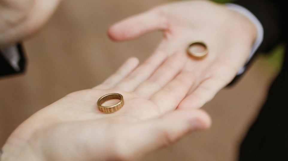 Ringe auf den ausgestreckten Handflächen der Eheleute