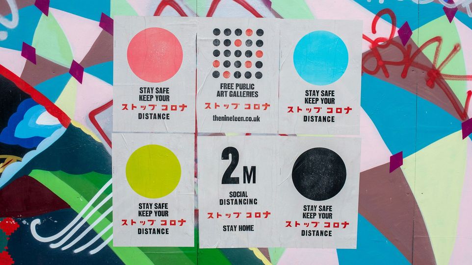 Plakate, die zum Einhalten sozialer Distanz auffordern