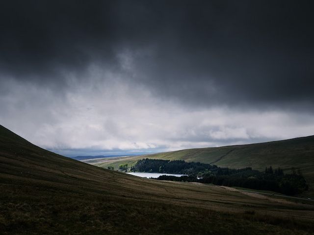 Dark rain clouds over hilly landscape