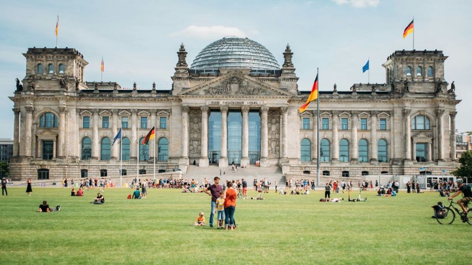 Bundestag, im Vordergrund Menschen auf der Wiese