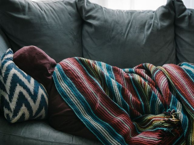 Rückenansicht einer auf dem Sofa liegenden Person