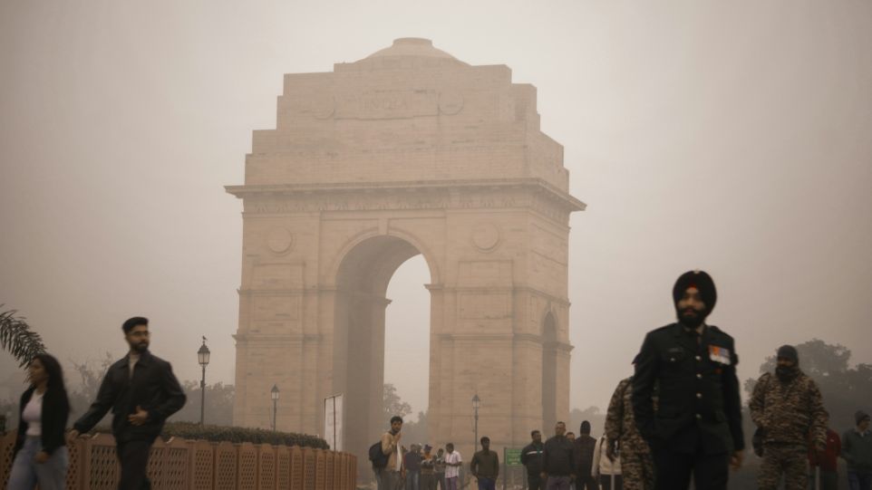 India Gate umhüllt von Nebel und umgeben von Menschen