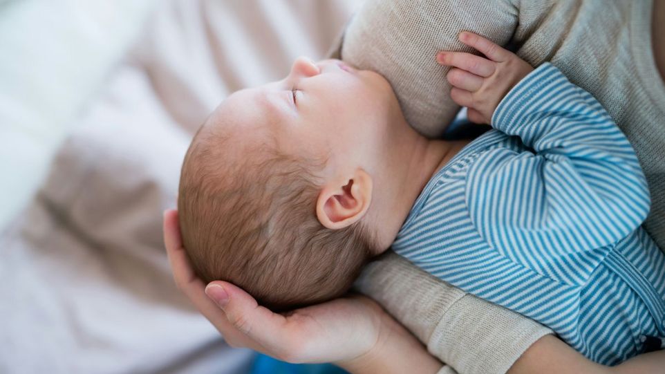 Säugling auf Arm der Mutter