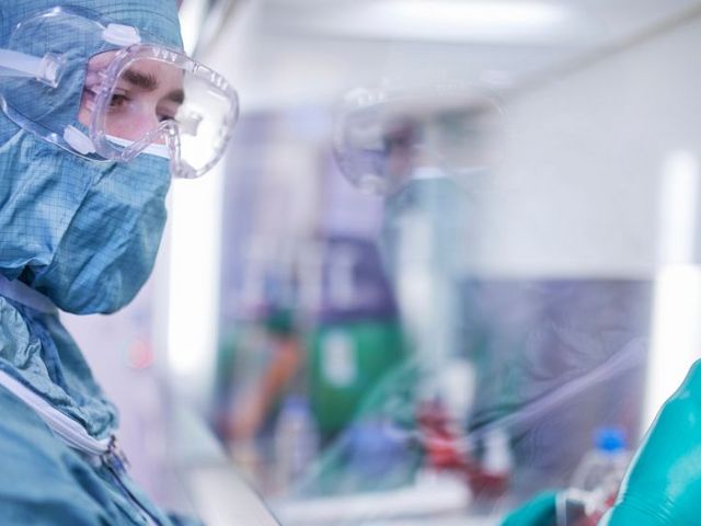 Eine Person in Schutzkleidung arbeitet in eine Labor