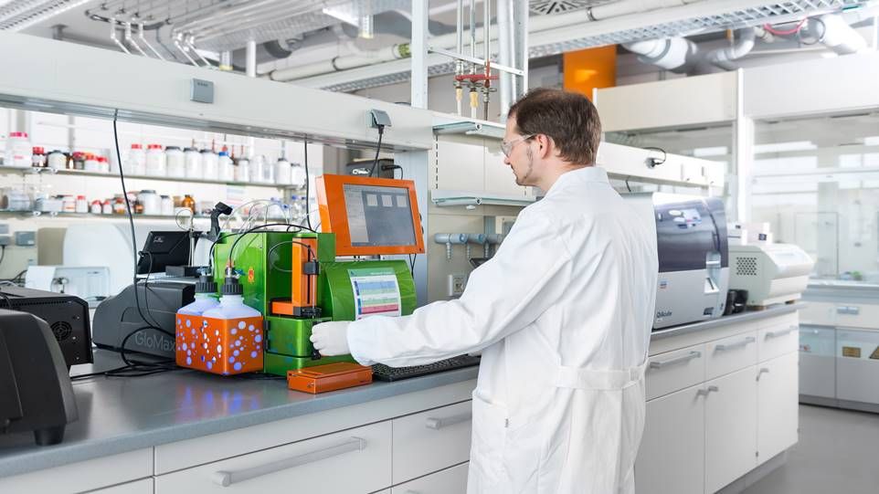 Wissenschaftler steht im Labor und arbeitet an grünem Messgerät