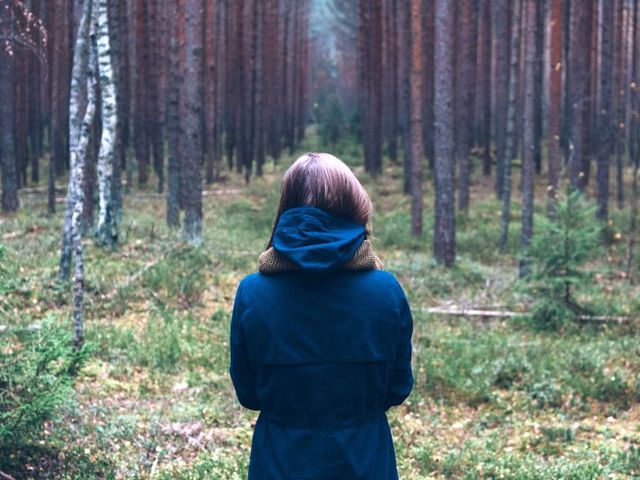 Frau, die auf einen Wald schaut
