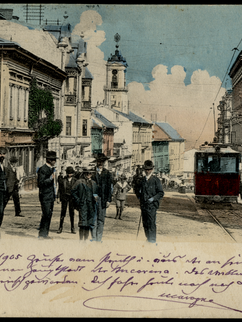 Ansichtskarte mit der Aufschrift Czernowitz, Rathausstraße. Sie zeigt nobel gekleidete Menschen in der Innenstadt sowie eine Straßenbahn. Die Karte ist vorne mit einer handschriftlichen Nachricht versehen. 