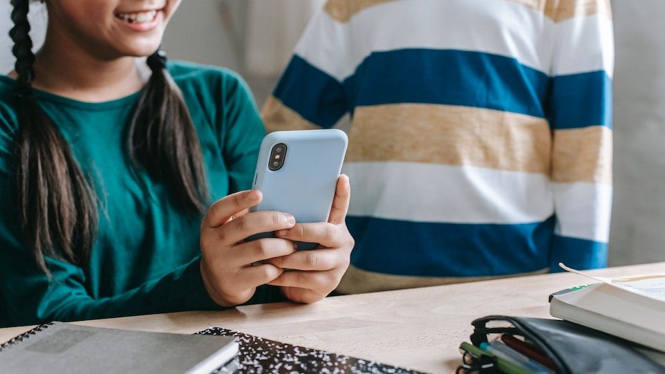 Maßnahmen des Jugendmedienschutzes funktionieren dann, wenn sie von Eltern wie Heranwachsenden gleichermaßen akzeptiert werden. Zwei Kinder mit einem Smartphone