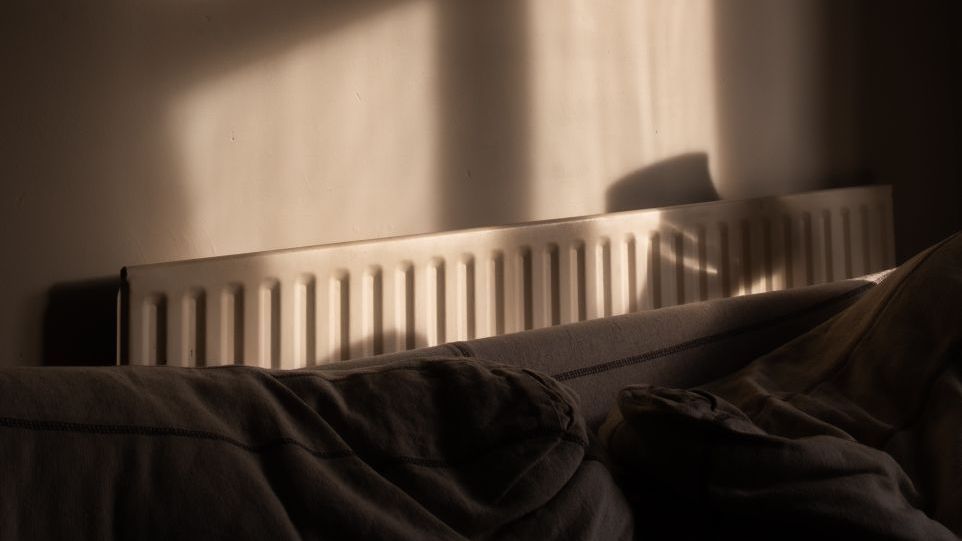 Heizkörper hinter dem Kopfende eines Bettes