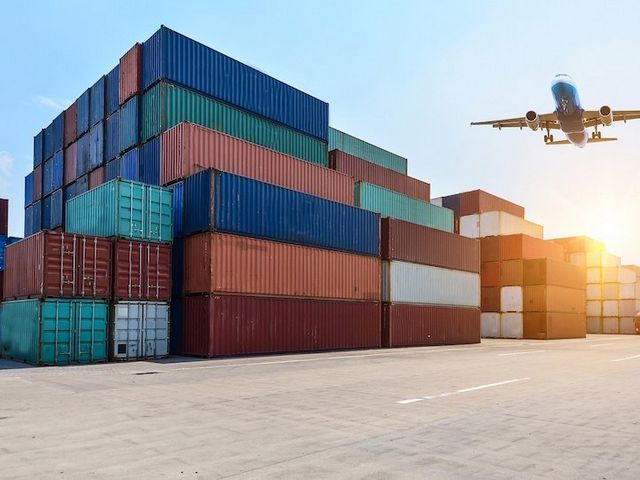 Container am Hafen, Flugzeug am Horizont