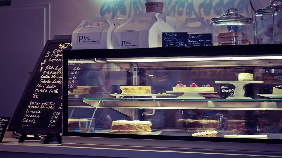 Cake counter in a café, various cakes and price board