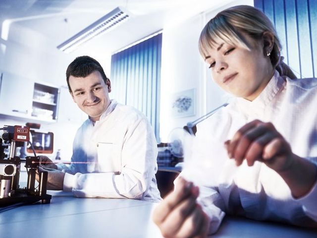 Young man and woman in white coats in the lab
