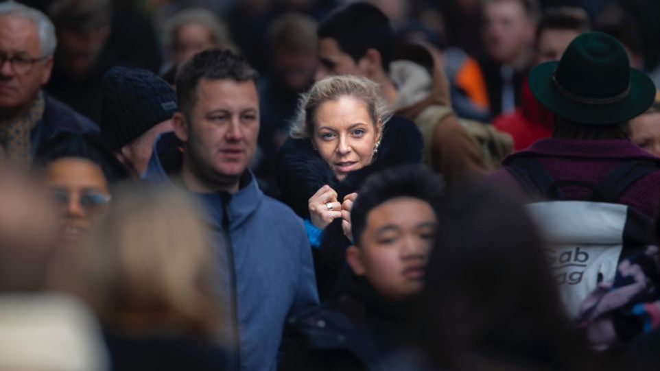 Menschenmenge, das Licht fällt auf das Gesicht einer Frau