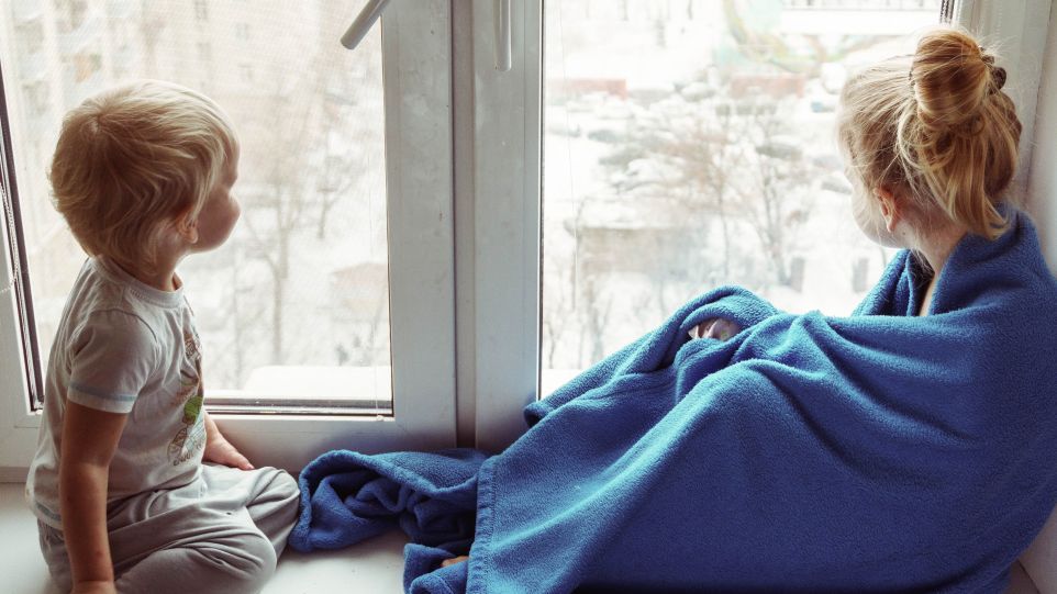 Besonders Kinder und ältere Menschen reagieren empfindlich auf Feinstaubbelastung. Zwei Kinder schauen aus dem Fenster