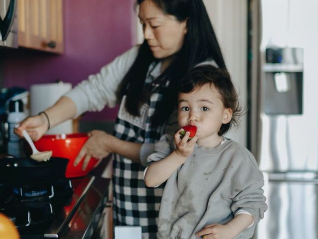 Kochende Mutter mit Kleinkind