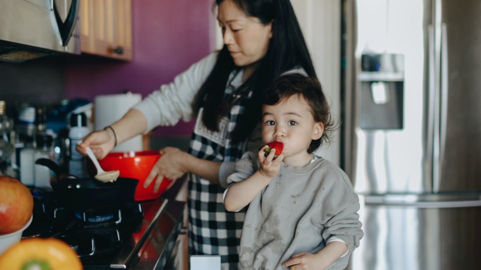 Kochende Mutter mit Kleinkind
