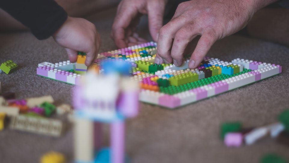 Kinder und Männerhände, mit Lego spielend